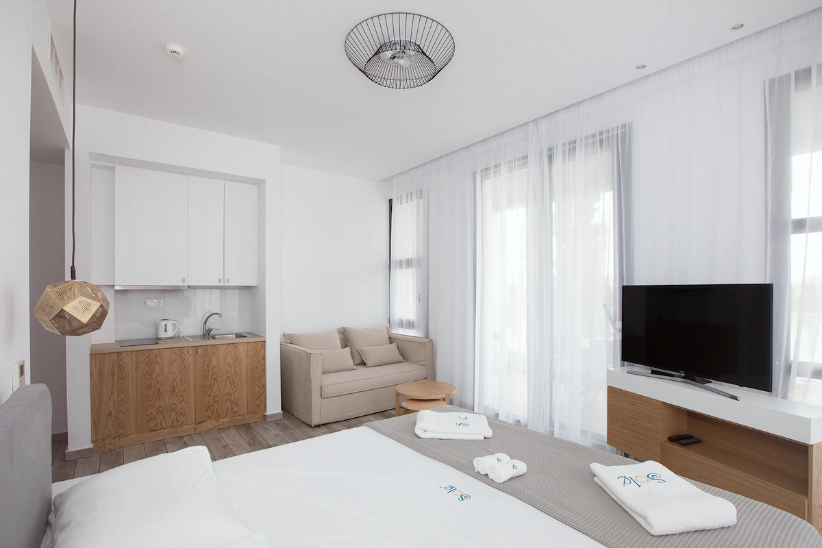 Bright room interior with balcony access at Suites Sole, Keramoti Greece