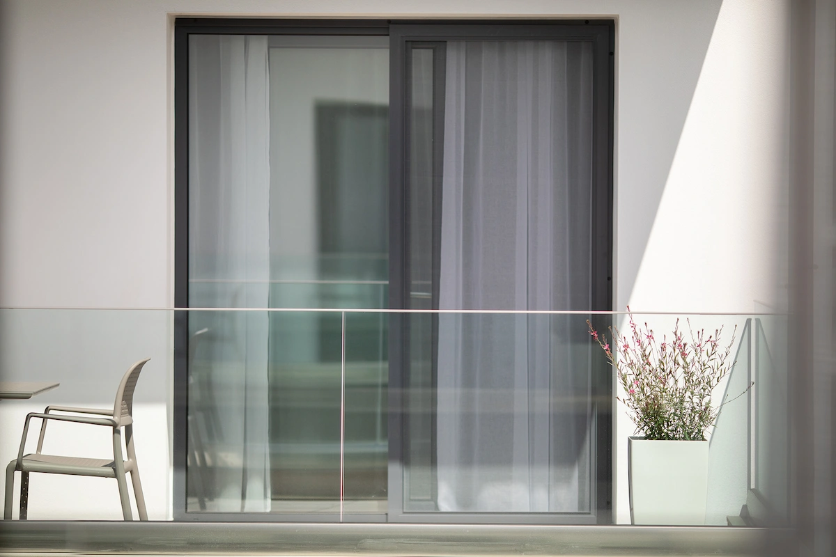 Private glass balcony with outdoor seating at Suites Sole, Keramoti Greece
